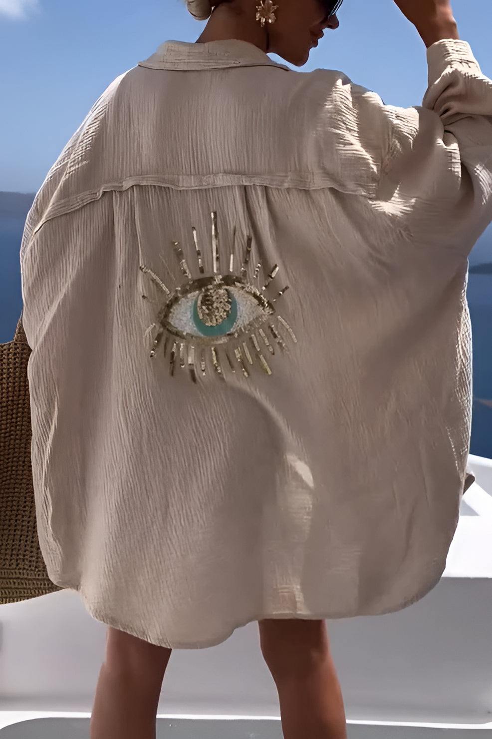 Belro evil eye shirt featuring sequin bead embellishments, shown in a close-up view of the stylish neckline and decorative details.