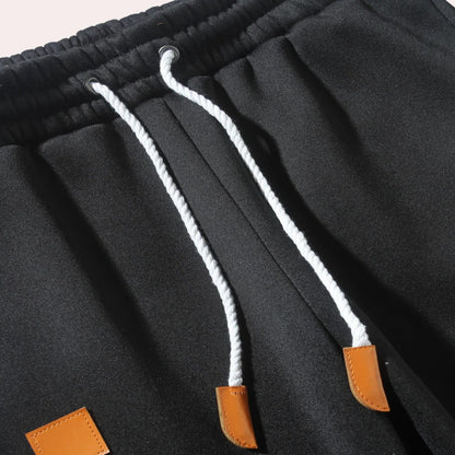 Men's Belro jogging pants in black, made of comfortable activewear fabric with side pockets and elastic waistband.