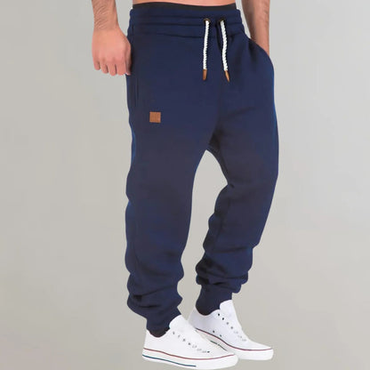 Men's Belro jogging pants in black, made of comfortable activewear fabric, shown folded with side pockets visible.