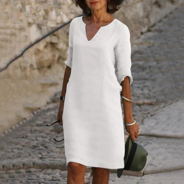 Belro V-neck three-quarter sleeve dress with a fitted silhouette, shown hanging on a wooden hanger.