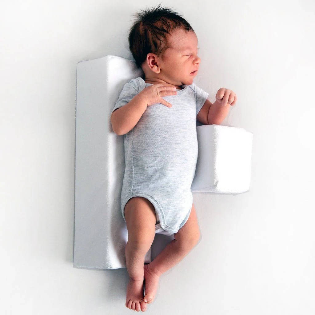 Belro newborn side sleeper wedge pillow for safer side sleeping in a crib, supporting baby’s head and body.