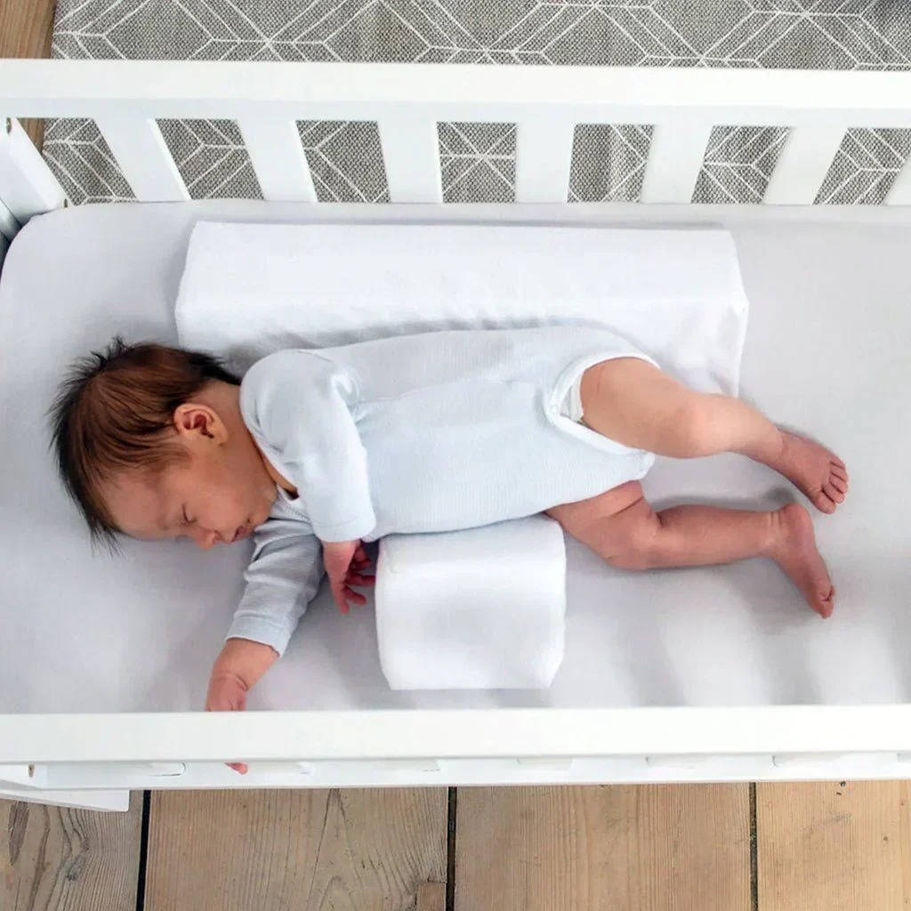 Belro newborn side sleeper wedge on a bed, designed for infant safety and comfort in bedding and pillow setup.