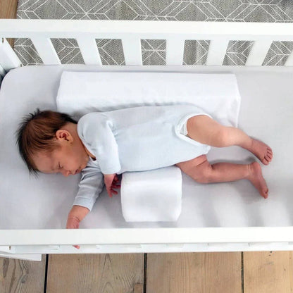 Belro newborn side sleeper wedge on a bed, designed for infant safety and comfort in bedding and pillow setup.