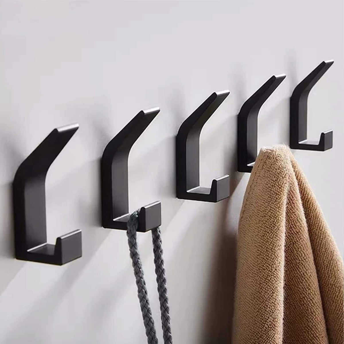 Set of five Belro self-adhesive wall hooks for coats, mounted on a wall in a home organization setting.