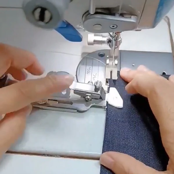 Belro sewing machine presser foot for men's clothing, showing the metal attachment and part of the sewing machine in use.