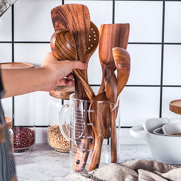 Set of natural teak wood kitchen utensils including cooking spoons, eco-friendly and non-toxic, ideal for home kitchen use.