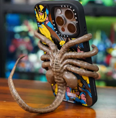 Belro Horrible Facehugger phone holder mounted on a desk, showcasing its unique design and secure grip for smartphones.