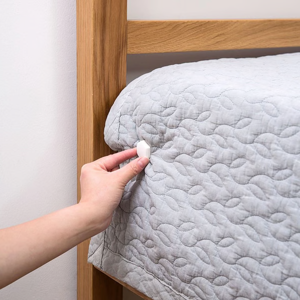 Belro bed sheet grippers clip set securing fitted sheets to mattress on a bed in a bedroom setting