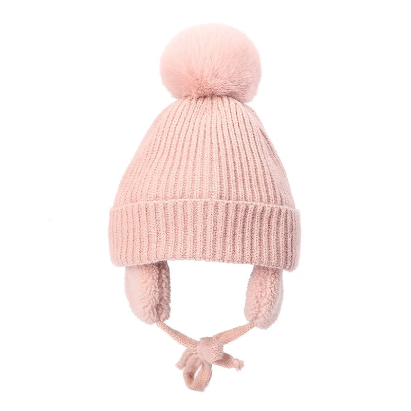 Pink kids knit beanie winter hat with earflaps from Belro, featuring cozy yarn and playful design for cold weather warmth.