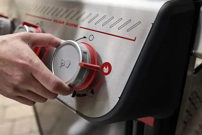 Casavibeo Weber Spirit E-325 gas grill with four burners, stainless steel lid, side shelves, and control knobs in the image.