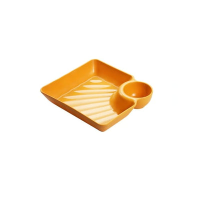 Mivoza dipping plate with sauce compartment, stackable and no-drip design, ideal for serving condiments and dips on a kitchen table.