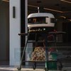 White Gozney Dome pizza oven by Casavibeo with ambient lighting, showcasing its sleek design and cooking surface.