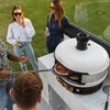 White Gozney Dome pizza oven with ambient lighting, showcasing its sleek design and cooking surface for outdoor pizza making.