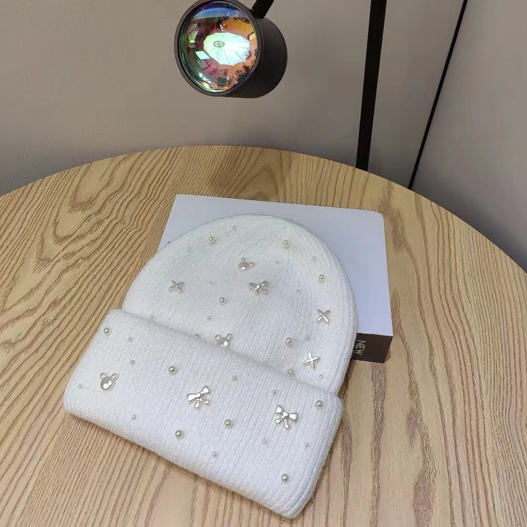 White Belro knit beanie with pearl accents, cozy winter hat featuring a soft knit texture and stylish design.